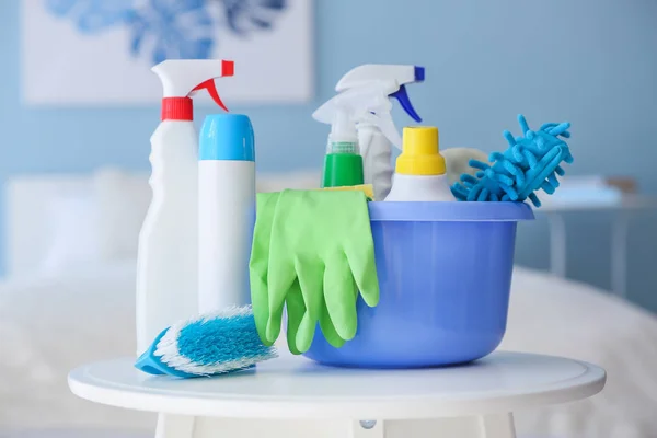 Set of cleaning supplies on table in room — Stock Photo, Image