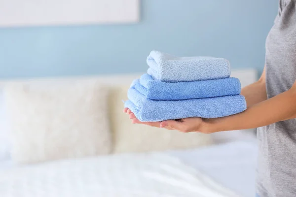 Домработница с чистыми полотенцами в спальне — стоковое фото