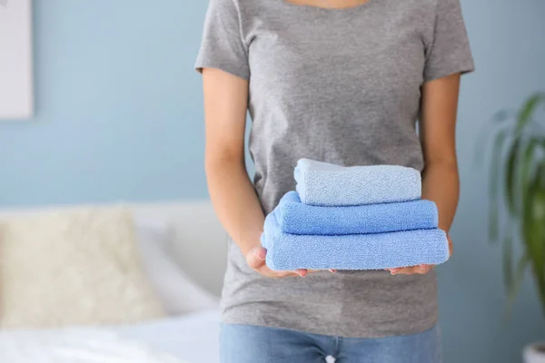 Governanta feminina com toalhas limpas no quarto — Fotografia de Stock