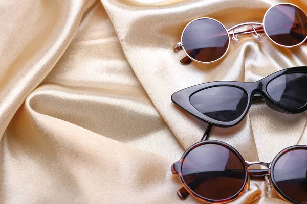 Diferentes gafas de sol elegantes sobre fondo de color — Foto de Stock