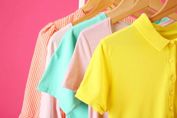 Rack with hanging clothes on color background, closeup — Stock Photo, Image
