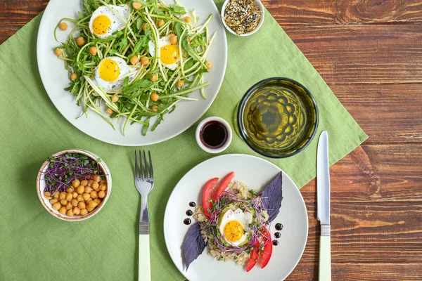 Тарелки с вкусными салатами на столе — стоковое фото