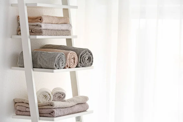 Clean towels on rack in room — Stock Photo, Image