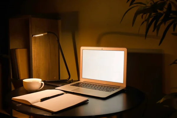 Modern arbetsplats med laptop på kvällen — Stockfoto