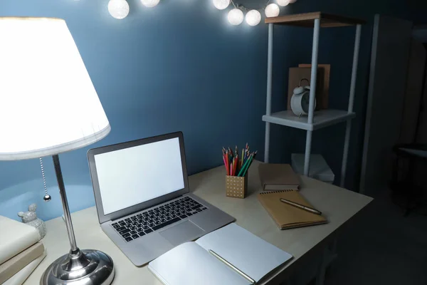 Modern workplace with laptop in evening — Stock Photo, Image