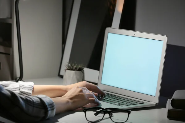 Mulher trabalhando no laptop à mesa à noite — Fotografia de Stock