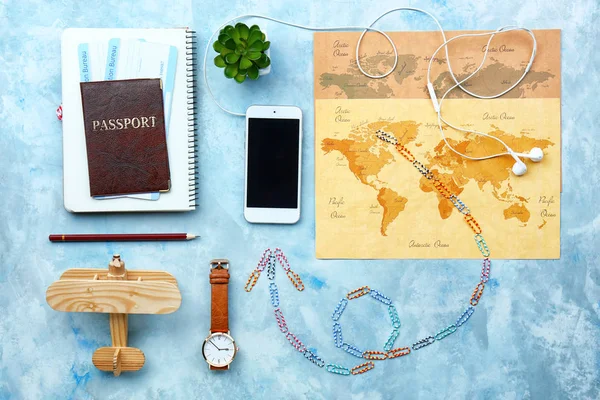 Composición con teléfono móvil moderno con mapa del mundo y pasaporte sobre fondo de color —  Fotos de Stock