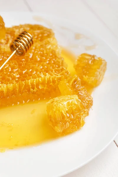 Čerstvé medové hřebeny a naběračka na desce, zaostřená — Stock fotografie