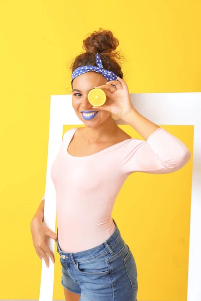 Портрет модного молодої афро-американської жінки з каркасом і лимоном на кольоровому фоні — стокове фото