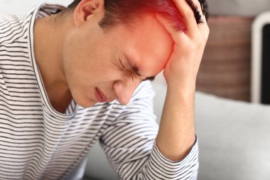 Genç adam evde baş ağrısı çekiyor.