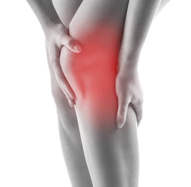 Beyaz zemin üzerinde diz ağrısı çeken kadın