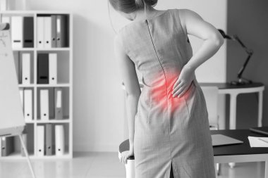 Ofiste sırt ağrısı çeken genç bir kadın.