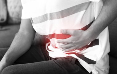 Genç adam karın ağrısı evde, closeup acı