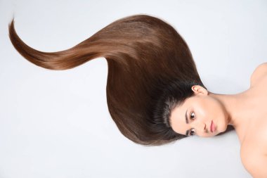 Hafif arka planda güzel düz saçlı genç kadın