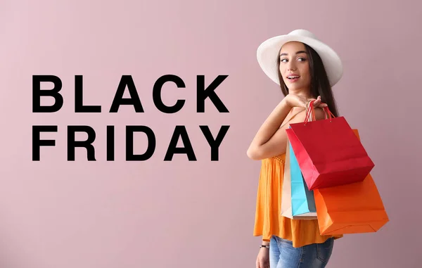 Vacker ung kvinna med shoppingväskor på färg bakgrund. Black Friday försäljning — Stockfoto