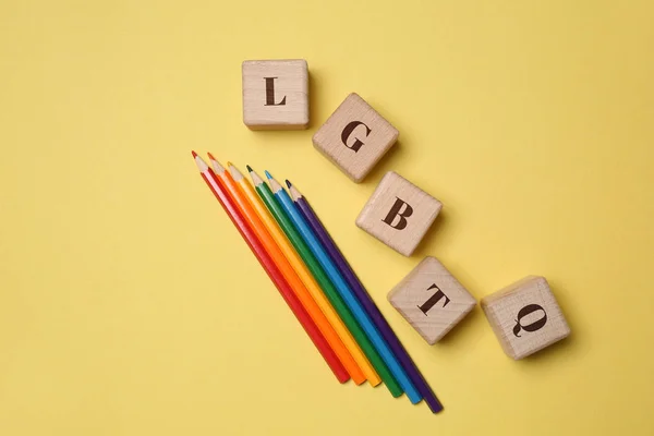 Wooden cubes with abbreviation LGBTQ and pencils on color background — Stock Photo, Image