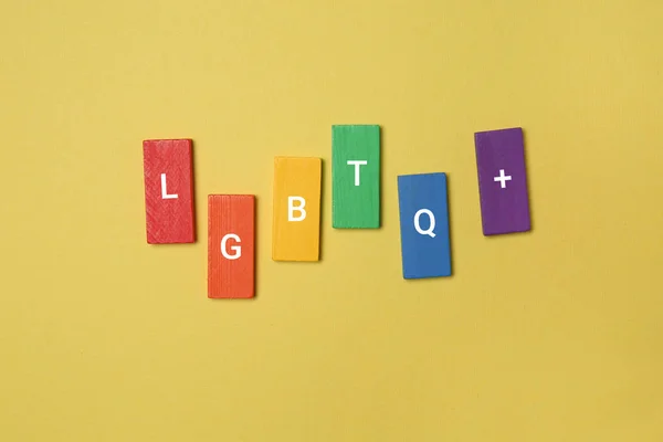 Wooden blocks with abbreviation LGBTQ on color background — Stock Photo, Image