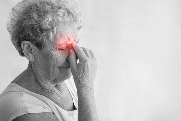 Mujer mayor que sufre de dolor de cabeza sobre fondo claro — Foto de Stock