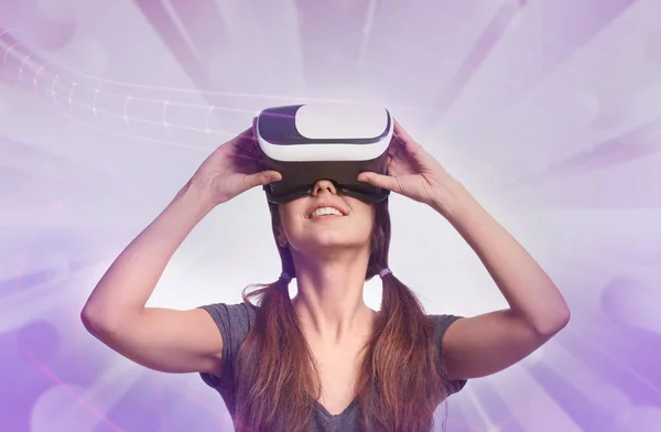 Junge Frau trägt Virtual-Reality-Brille auf farbigem Hintergrund — Stockfoto