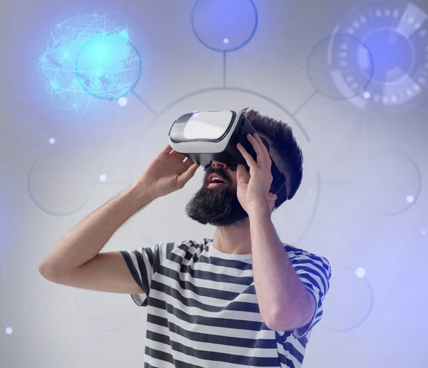 Mann trägt Virtual-Reality-Brille auf hellem Hintergrund — Stockfoto