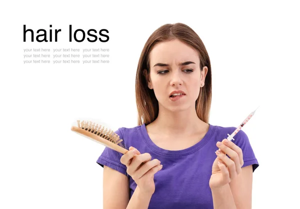 Mujer con problemas de pérdida de cabello sosteniendo el cepillo y la jeringa sobre fondo blanco — Foto de Stock