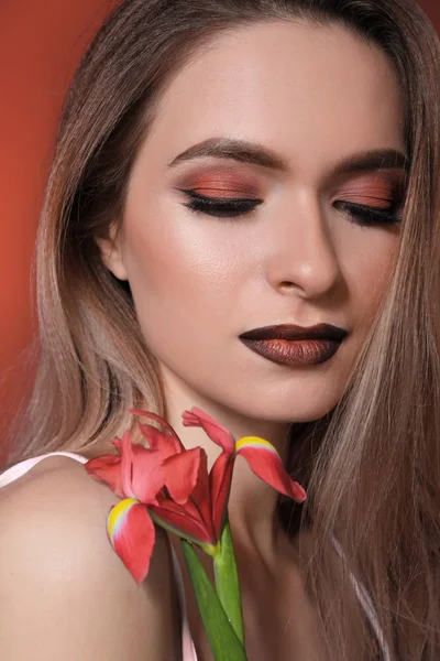 Beautiful young woman with makeup in coral tones and flower — Stock Photo, Image