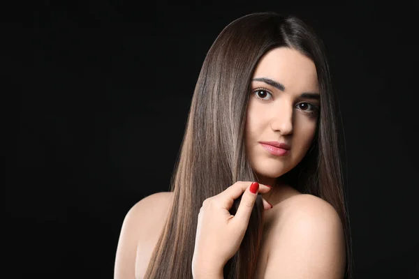 Portrait of young woman with beautiful straight hair on dark background — Stock Photo, Image
