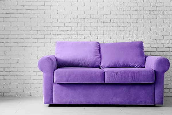 Kényelmes kanapé-közel könnyű tégla fal a szobában — Stock Fotó
