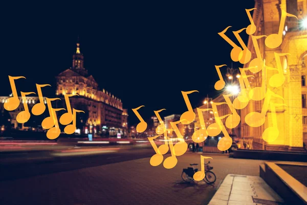 Notas de música voadora na rua da cidade à noite — Fotografia de Stock