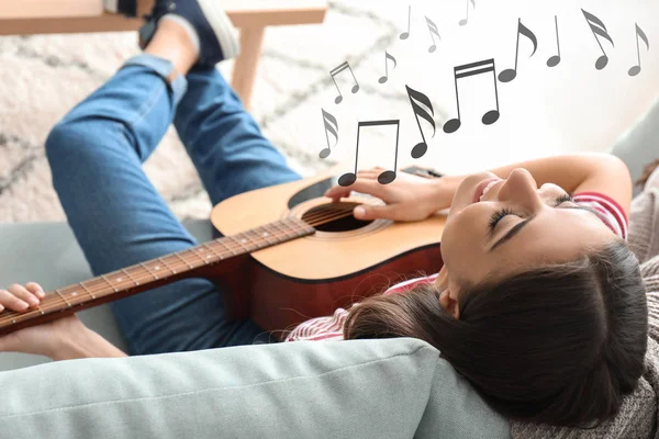 Vacker kvinna spelar gitarr hemma — Stockfoto