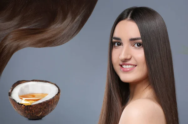 Young woman with beautiful long hair and coconut oil on grey background — Stock Photo, Image
