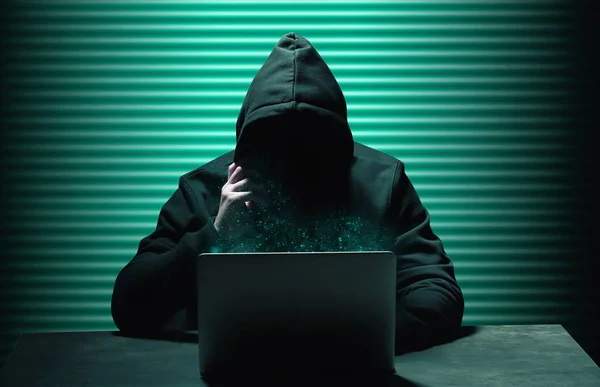 Hacker profissional com laptop sentado à mesa — Fotografia de Stock