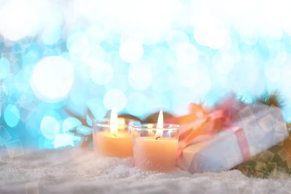 Kaarsen en de doos van de gift van Kerstmis op sneeuw tegen wazig lights — Stockfoto