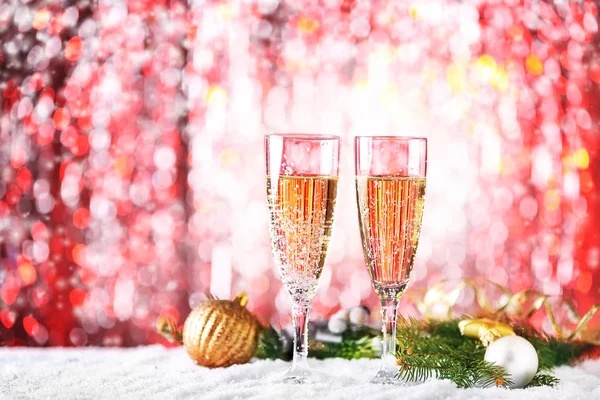 Kieliszki szampana i Świąteczna dekoracja na śniegu przed rozmytymi — Zdjęcie stockowe