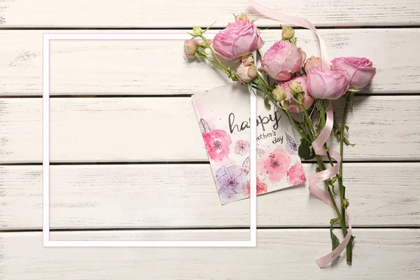 Blommor, blank ram och kort med text Happy mors dag på trä bakgrund — Stockfoto