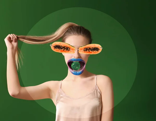 Смішний колаж жінки з цукерками в роті і папайя окуляри на кольоровому фоні — стокове фото