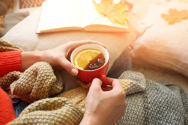 Mladá žena s šálkem horkého čaje odpočívá doma — Stock fotografie
