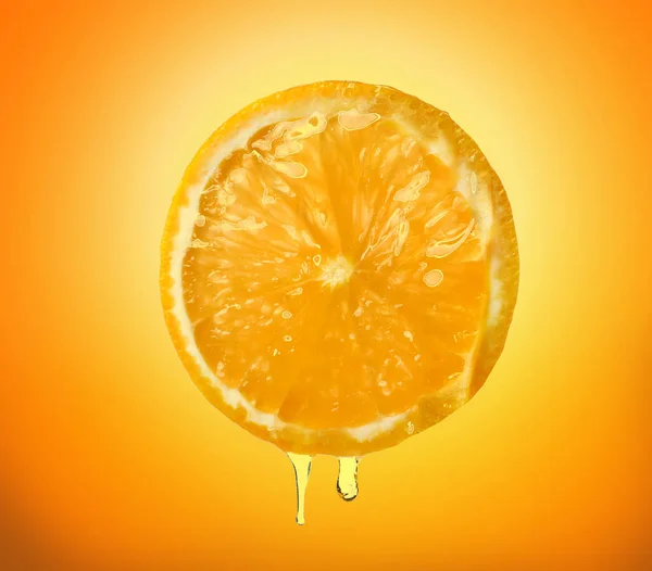 Essential oil dripping from orange slice on color background