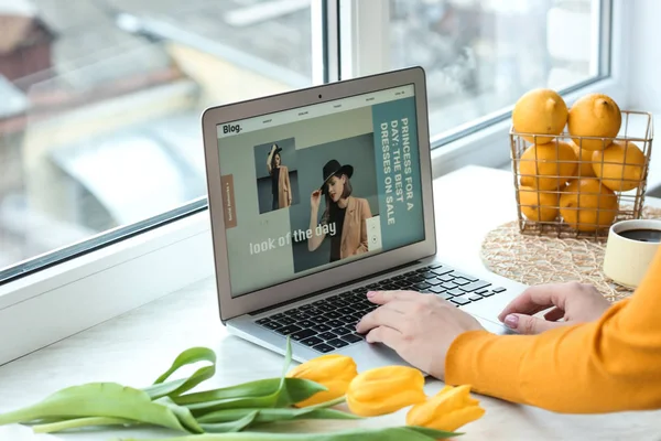 Blogueiro de moda feminina trabalhando em laptop perto da janela — Fotografia de Stock
