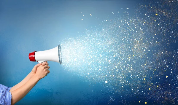 Woman with megaphone and glitters on color background — Stock Photo, Image