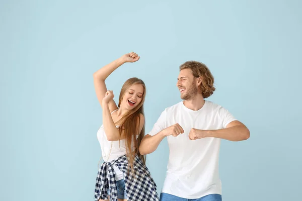 Cool young couple dancing against color background — Stock Photo, Image