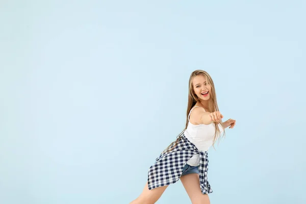 Chladná mladá žena tančí proti barevnému pozadí — Stock fotografie