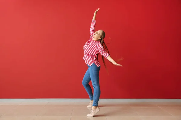 Coole jonge vrouw dansen tegen kleur muur — Stockfoto