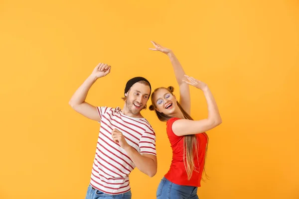 Cool young couple dancing against color background — Stock Photo, Image