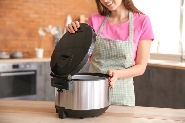 Женщина с современной мульти-плита на кухне — стоковое фото