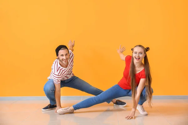 Cool young couple dancing against color wall — Stock Photo, Image