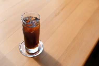 Ahşap masada soğuk kola bardağı
