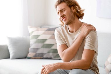 Evde omzunda ağrı olan genç adam