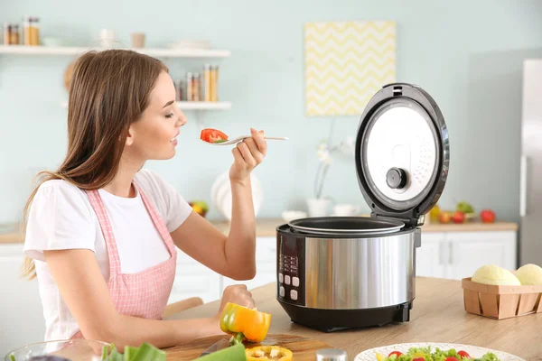 Vrouw met behulp van moderne multi fornuis in de keuken — Stockfoto