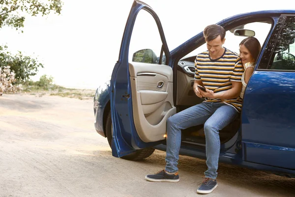 Happy couple using mobile phone for navigation in countryside — Stock Photo, Image